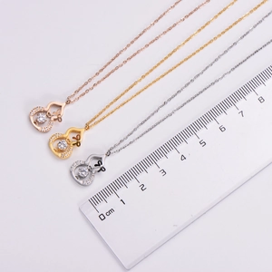 Detail view of gourd-shaped pendant necklaces in gold and silver with size measurement scale