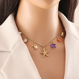 Gold necklace with starfish, turtle, shell, and star charms shown on a model neck