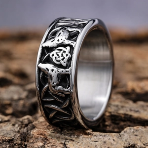 Macro shot of Viking wolf ring featuring intricate Nordic relief and Celtic knots on bark