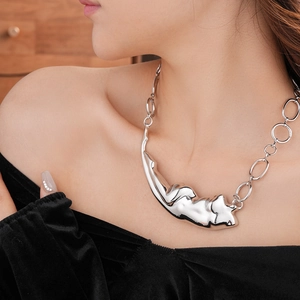 Gros plan d'un collier en métal irrégulier avec une grosse chaîne à maillons argent