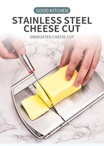 Detail of stainless steel cheese slicer cutting butter on a scaled marble grid base