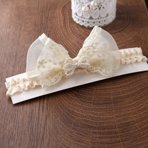 Bandeau bébé fille en dentelle blanche avec grand nœud en tulle et centre en perles