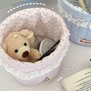 Close-up of pink and blue striped fabric storage baskets with lace trim and polka dot lining