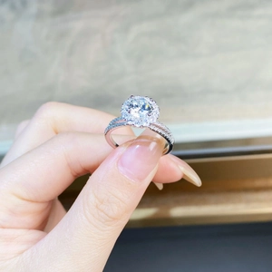 Detailed view of a 925 sterling silver moissanite ring held by hand to show its brilliance