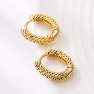 Retro mini gold plated hoop earrings with woven texture on white ceramic plate