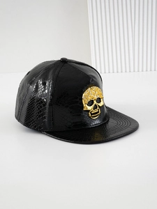 Detail of black faux leather baseball cap with a gold rhinestone skull emblem