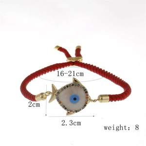 Detail of red rope bracelet with gold evil eye fish pendant and crystal inlay