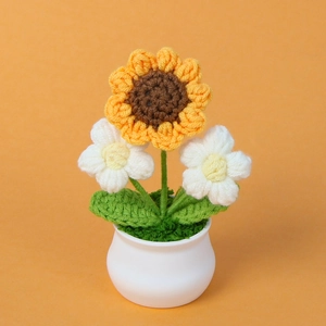 Handgemaakte gehaakte zonnebloem in keramische pot met kleine witte bloemetjes