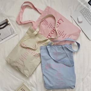 Mise à plat de sacs fourre-tout en toile colorés avec lettrage floral et accessoires