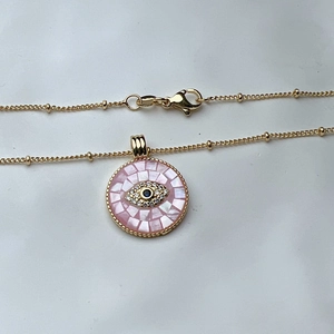 Pink shell evil eye pendant necklace with gold chain and blue zircon crystal details