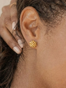 Close-up of 18k gold plated rose earrings on a model showing detailed floral petal design