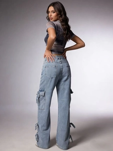 Women's light blue cargo jeans with bow tie cuffs and utility pockets in side view