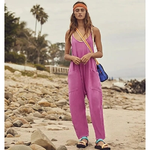 Women's purple bohemian jumpsuit with zipper pockets shown in a beach setting