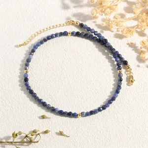 Detail of blue natural stone bead necklace with golden spacers and adjustable lobster clasp