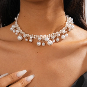 Detail of baroque pearl necklace with layered beads and rhinestones on neck