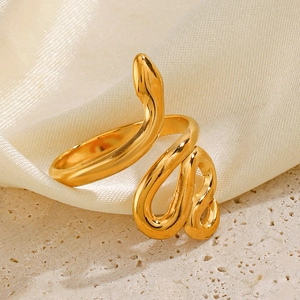 Minimalist golden stainless steel snake-shaped open ring on an elegant beige silk background