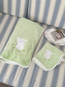 Detail of soft green coral fleece towel set with cute lamb embroidery and white piping