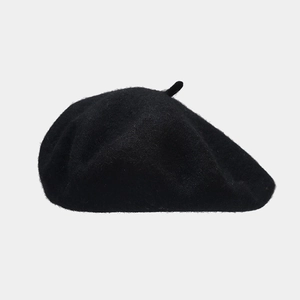 Detailopname van zwarte wollen baret met dikke stoftextuur en klassieke bovenkant