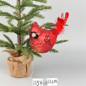 Detail of red cardinal glass ornament with sequins and real feathers on Christmas tree