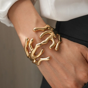 Detailed macro view of the polished gold irregular multi-layer open cuff bracelet