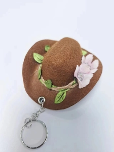 Miniature brown felt cowboy hat keychain with green leaves and pink flowers detail