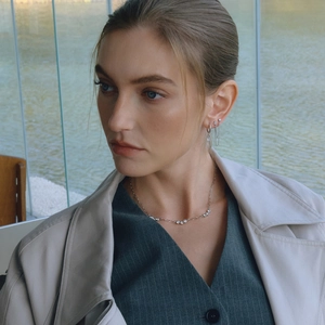 Close-up of a silver titanium steel necklace with zircon stones worn by a model