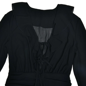 Close-up of black V-neck chiffon dress featuring ruffle trim and lace-up chest detail