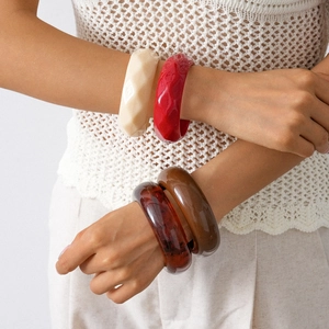 Close-up of geometric acrylic resin bangles with diamond-cut and polished finishes