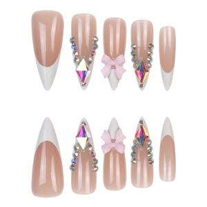 Macro detail of long stiletto press-on nails with white French tips and pink 3D bows