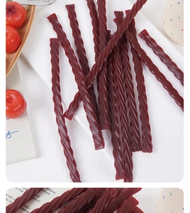 Macro shot of dark red spiral twisted hawthorn candy strips on a white plate