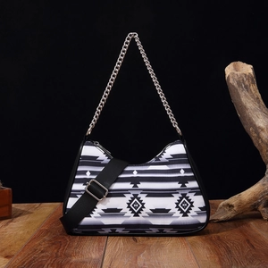 Detail of bohemian handbag with black and white geometric patterns and silver chain strap