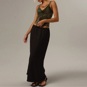 Detail eines dunkelgrünen Camisole mit V-Ausschnitt und schwarzem Maxirock mit hoher Taille