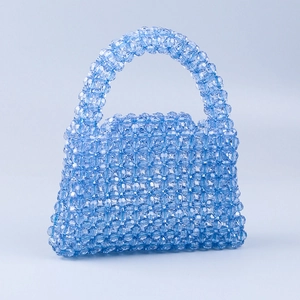 Detail shot of blue acrylic beads on a mini trapezoid handbag with weaving texture
