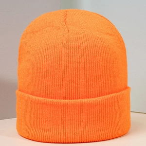 Gros plan d'un bonnet en maille orange vif avec texture côtelée et bord replié épais