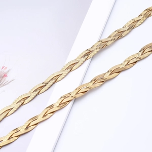 Close-up of triple-layered woven snake bone chain necklace in polished golden finish