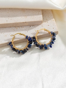 Detail of handmade gold hoop earrings wrapped with blue crushed natural stones