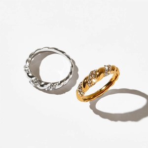 Macro detail of twisted rope rings with PVD plated gold and silver finish and rhinestones