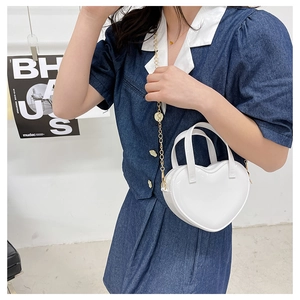 Model wearing a white heart-shaped jelly bag with gold chain strap and glossy finish