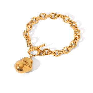 Macro shot of gold stainless steel chain bracelet with OT toggle clasp and irregular pendant