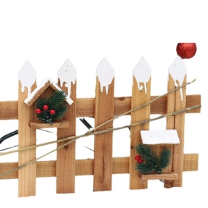 Clôture de sapin en bois avec aiguilles de pin enneigées et baies rouges déco