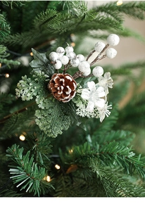 Close-up of pine cones and white berries on a Christmas tree with warm lights