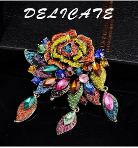 Detailed macro view of a Baroque-style colorful rhinestone brooch on a black gift box