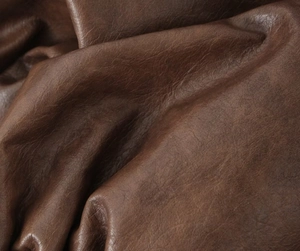 Macro de la texture en cuir vintage marron foncé montrant le grain doux et le brillant