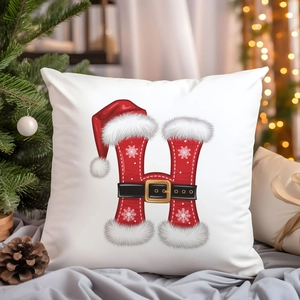 White Christmas pillow cover with Santa-style letter H on a cozy holiday background