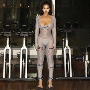 Detail view of lace sheer jumpsuit with deep V-neck and dark blue bows on sleeves and legs
