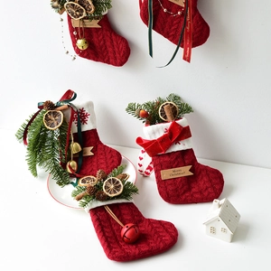Calcetines de Navidad de punto rojo con piñas, canela y etiquetas de Feliz Navidad