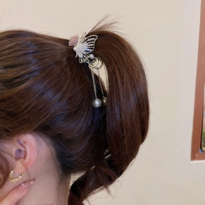 Detail of floral butterfly hair claw with rhinestone tassels and elegant pearls