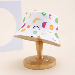 Detail of white cotton sun hat featuring vibrant fruit patterns and Sweet Fruit text