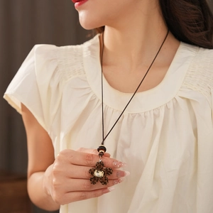 Détail du pendentif fleur léopard avec cristal sur un collier en résine de style rétro