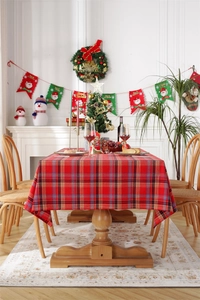 Close-up of a festive red and green plaid Christmas tablecloth on a dining table
